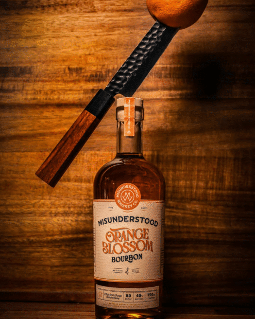 A bottle of orange blossom bourbon with a wood background